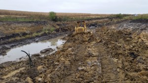 I started rolling the sandy clay off the side hill, stair stepping my way down to the water that remained. The core was now high enough to push the resulting slop up on to the front side of the dam, spreading some of it out to dry, and piling the rest to peel into later.